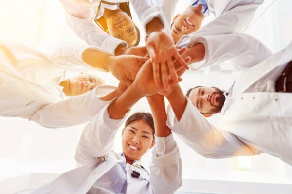 doctors-united-1200 doctors putting hands in the middle