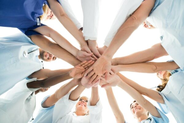 team-of-dentists-1200 dentists putting hands in middle