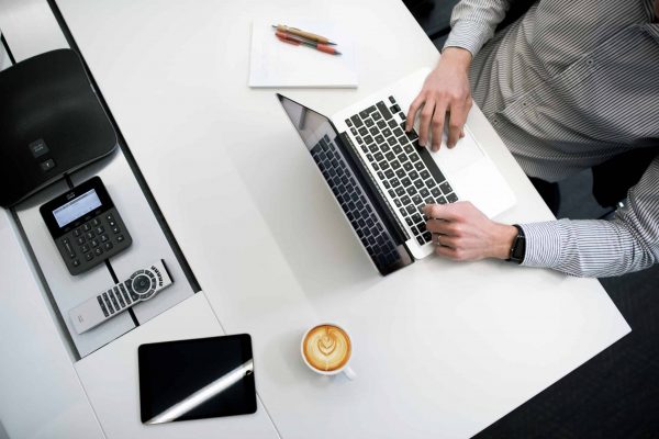 Person working on a laptop, representing the digital research into the differences between invoice financing and factoring.