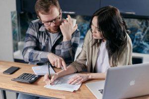 A couple discussing their invoice, symbolizing the strategic discussions around business invoice financing.